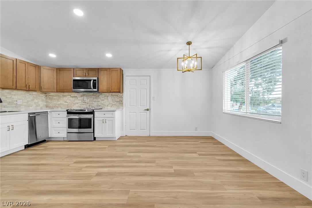 1604 Basswood Avenue, North Las Vegas, NV 89030 Warm wood-look flooring and a modern chandelier highlight this versatile kitchen and dining space.