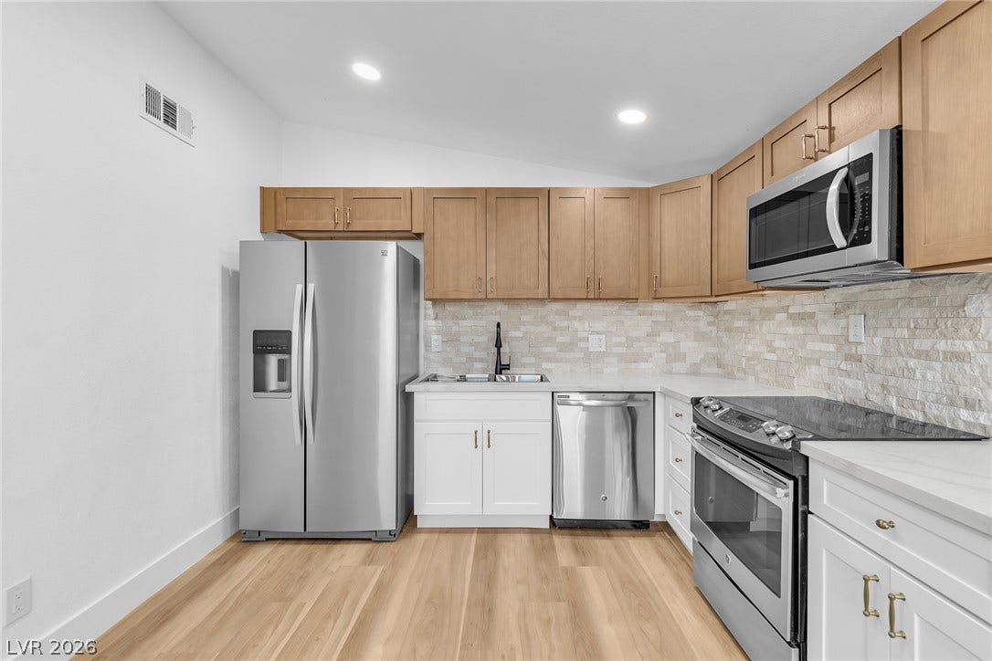 1604 Basswood Avenue, North Las Vegas, NV 89030 Warm wood cabinetry pairs with stainless steel appliances over light hardwood flooring.