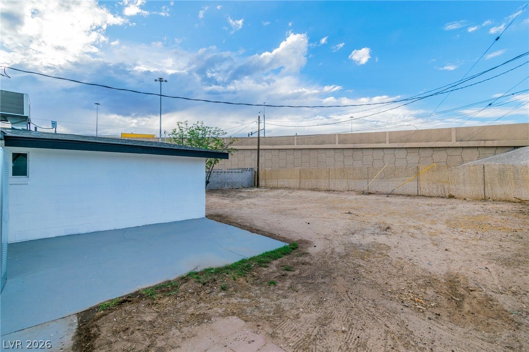 1604 Basswood Avenue, North Las Vegas, NV 89030 An open backyard space sits adjacent to a concrete patio area under wide open skies.