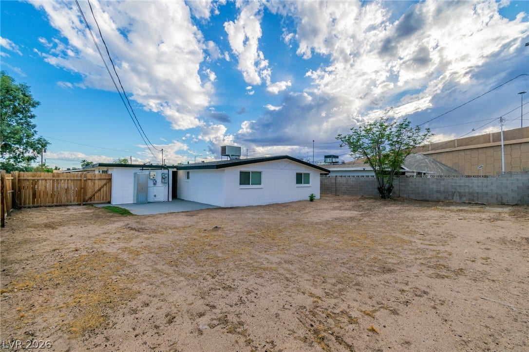 1604 Basswood Avenue, North Las Vegas, NV 89030 An expansive backyard space offers privacy and potential for customization behind the classic stucco home.
