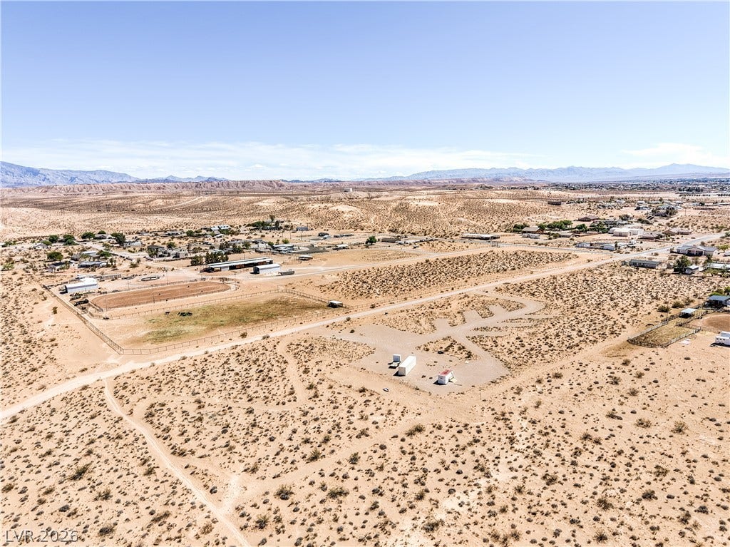 Skyline, Logandale, NV 89021 A vast desert landscape unfolds under a clear sky with distant mountain peaks on the horizon.