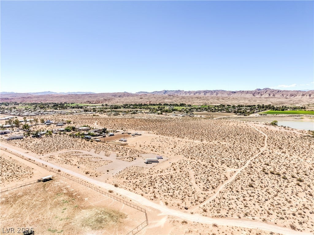 Skyline, Logandale, NV 89021 A vast desert landscape stretches toward rugged mountain ranges under a clear blue sky.