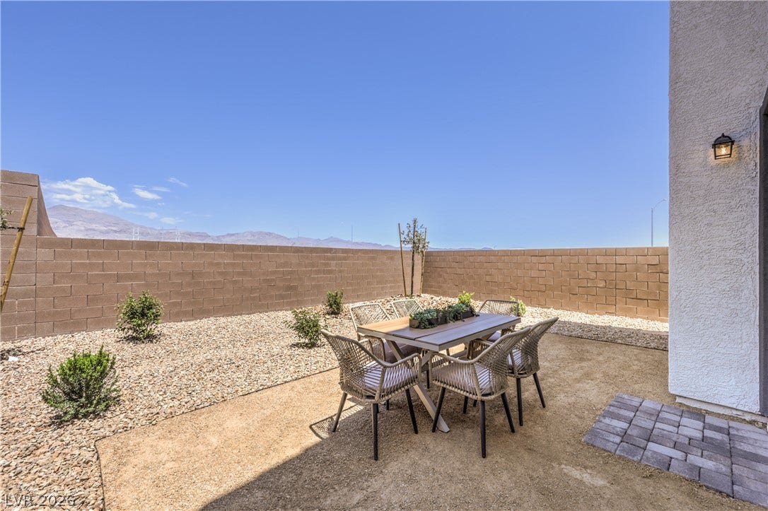 844 Kassie Lake Way, North Las Vegas, NV 89084 An enclosed backyard patio framed by a block wall looks out toward distant mountain peaks. Representational only; Photo is of the 2660 Plan Model Home - NOT THE ACTUAL HOME FOR SALE *material/features/colors can vary from one community to the next & are subject to change*