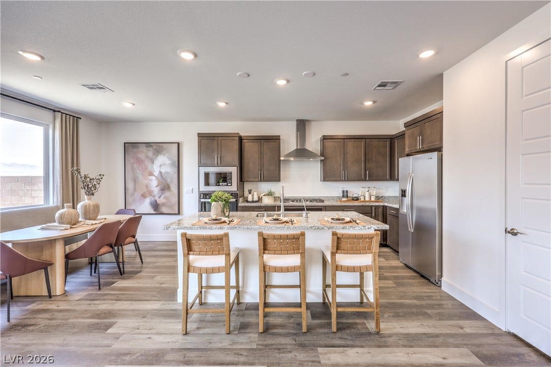 844 Kassie Lake Way, North Las Vegas, NV 89084 Recessed lighting illuminates this modern culinary space featuring a central island and warm wood-style flooring. Representational only; Photo is of the 2660 Plan Model Home - NOT THE ACTUAL HOME FOR SALE *material/features/colors can vary from one community to the next & are subject to change*