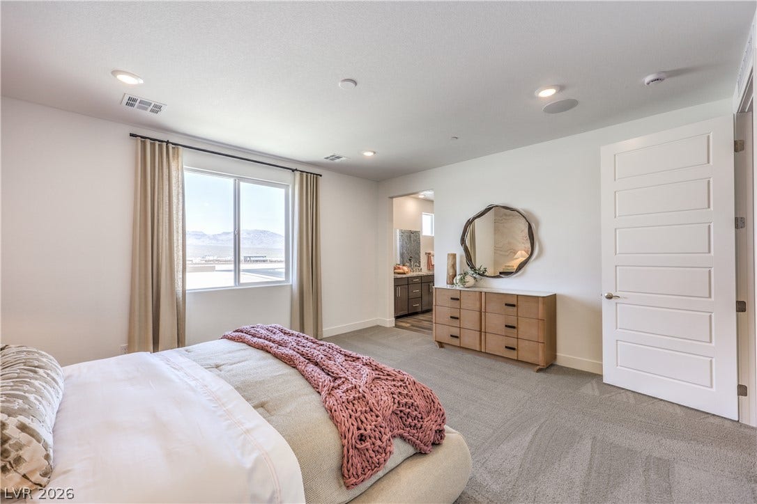 844 Kassie Lake Way, North Las Vegas, NV 89084 A spacious bedroom features neutral carpeting, recessed lighting, and a large window looking outdoors. Representational only; Photo is of the 2660 Plan Model Home - NOT THE ACTUAL HOME FOR SALE *material/features/colors can vary from one community to the next & are subject to change*