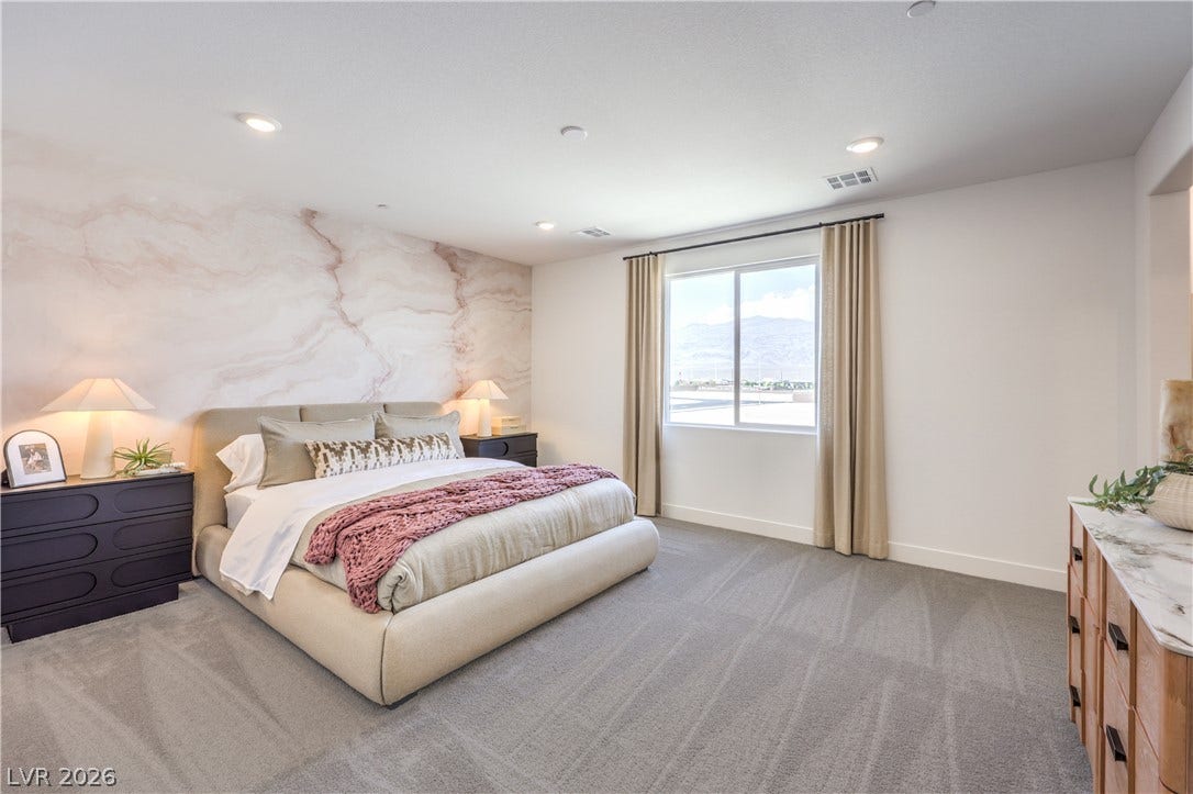 844 Kassie Lake Way, North Las Vegas, NV 89084 Recessed lighting and soft carpeting create a tranquil atmosphere in this bedroom with mountain views.