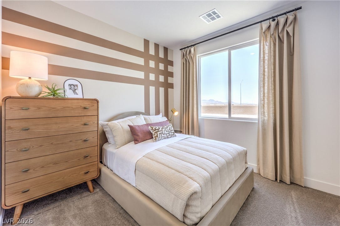 844 Kassie Lake Way, North Las Vegas, NV 89084 Plush carpeting underfoot and a large window framing distant mountain views elevate this comfortable bedroom. Representational only; Photo is of the 2660 Plan Model Home - NOT THE ACTUAL HOME FOR SALE *material/features/colors can vary from one community to the next & are subject to change*