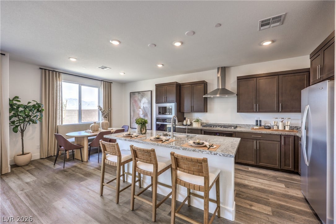 844 Kassie Lake Way, North Las Vegas, NV 89084 Rich wood cabinetry and stone countertops anchor this modern open-concept culinary space. Representational only; Photo is of the 2660 Plan Model Home - NOT THE ACTUAL HOME FOR SALE *material/features/colors can vary from one community to the next & are subject to change*