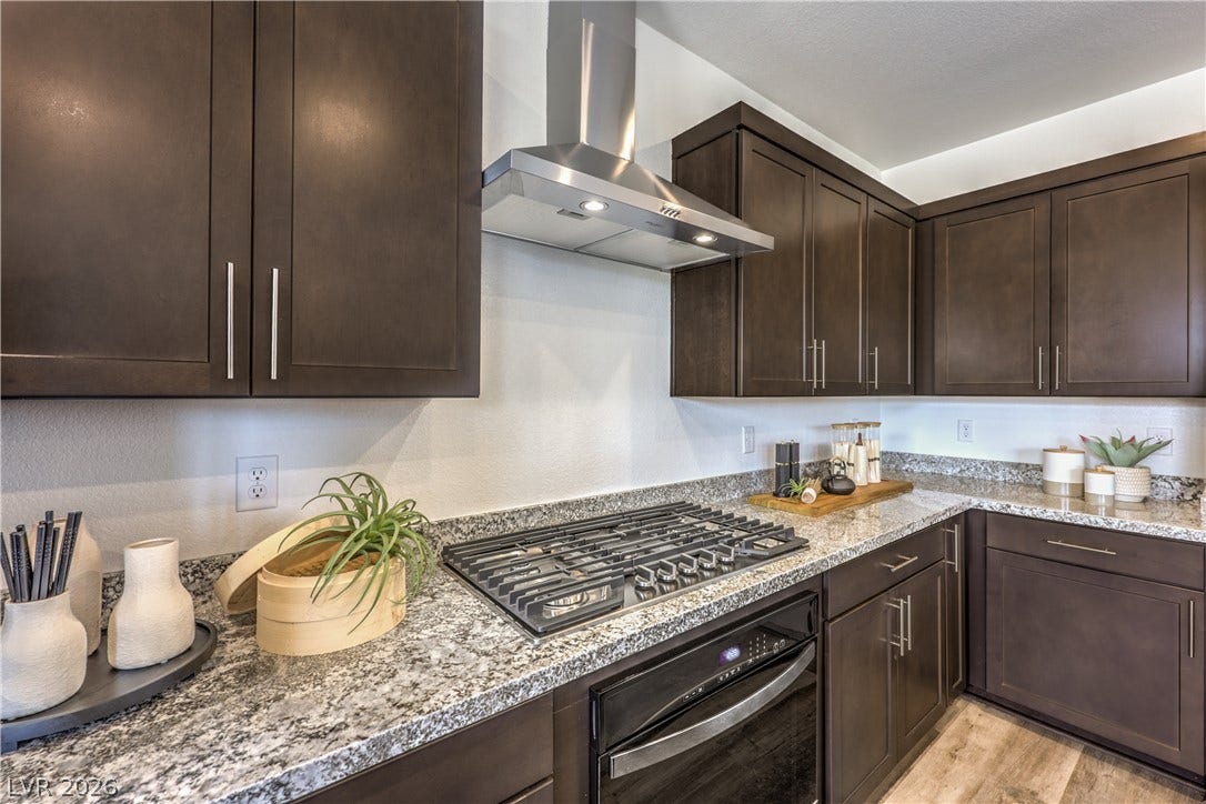844 Kassie Lake Way, North Las Vegas, NV 89084 Rich dark cabinetry pairs beautifully with sleek granite countertops and modern built-in appliances. Representational only; Photo is of the 2660 Plan Model Home - NOT THE ACTUAL HOME FOR SALE *material/features/colors can vary from one community to the next & are subject to change*
