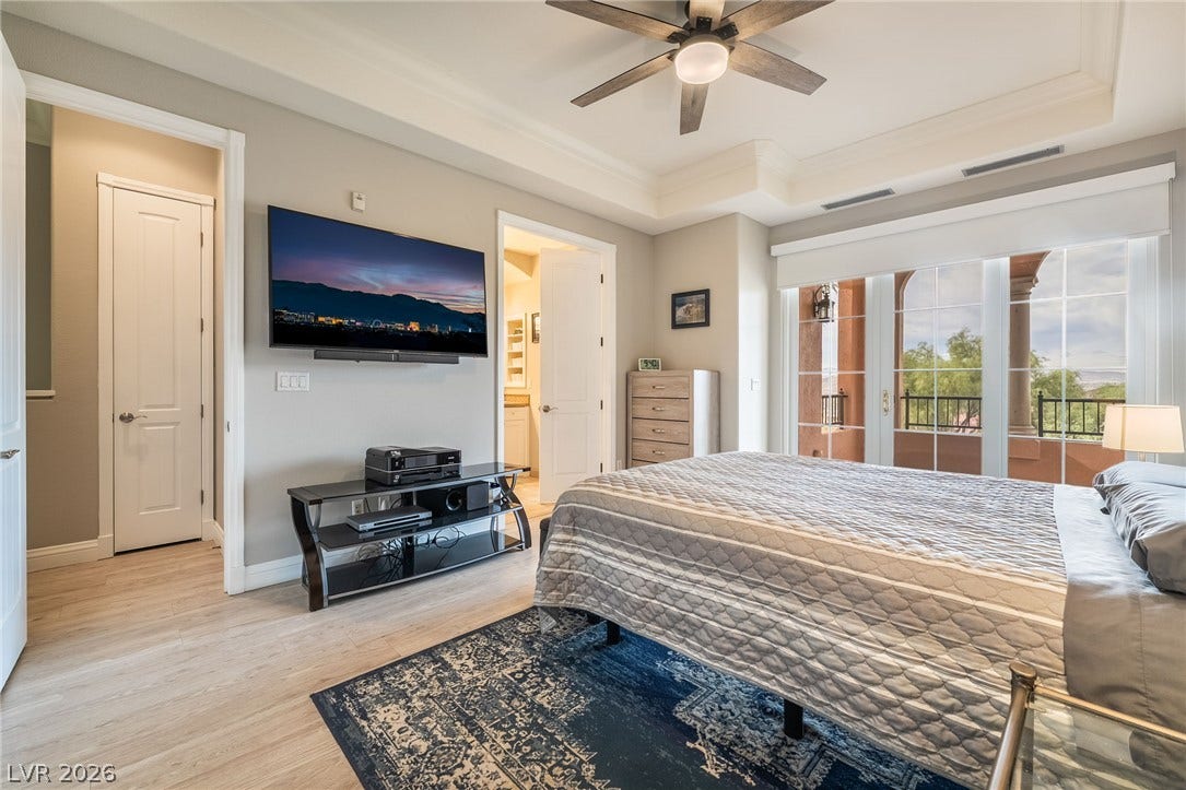 30 Via Vasari, #103, Henderson, NV 89011 Crown molding and a tray ceiling frame this comfortable space with private balcony access.