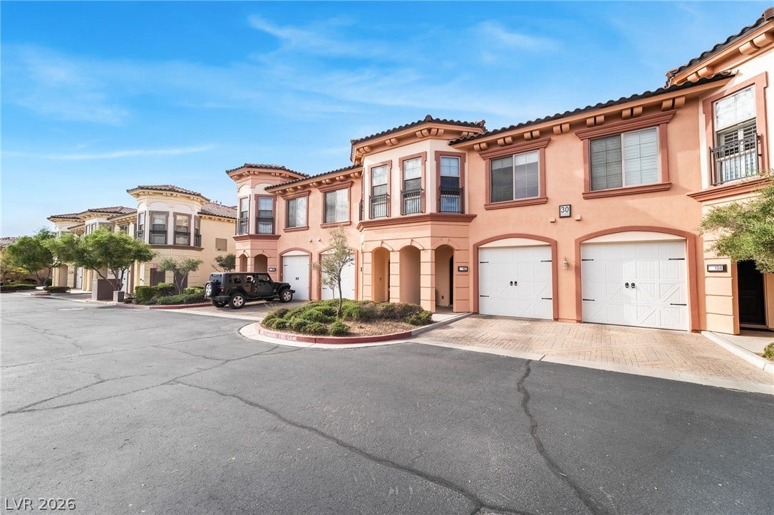 30 Via Vasari, #103, Henderson, NV 89011 Mediterranean architectural details and integrated multi-car garages define this multi-level residential exterior.