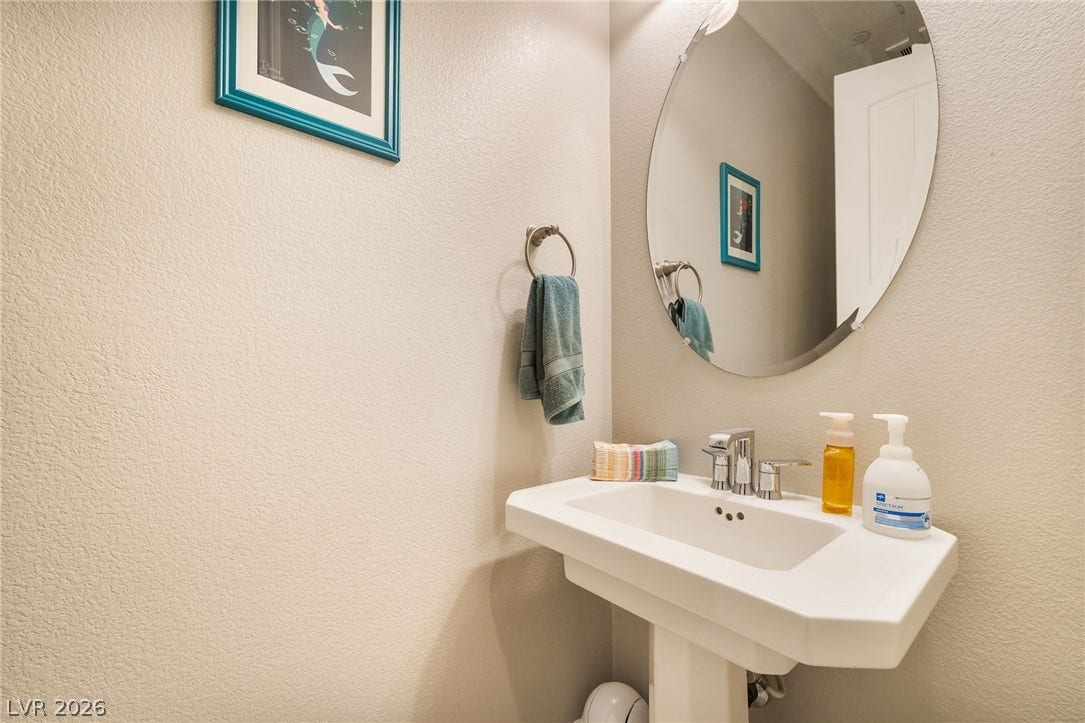 30 Via Vasari, #103, Henderson, NV 89011 A classic pedestal sink and oval mirror anchor this neat powder room.