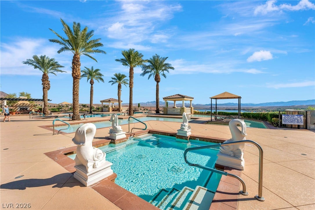 30 Via Vasari, #103, Henderson, NV 89011 A sparkling pool and spa area are framed by towering palms and distant mountain views.