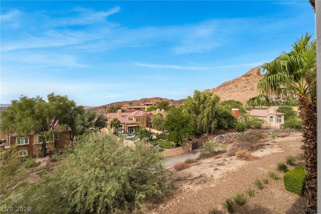 30 Via Vasari, #103, Henderson, NV 89011 Panoramic neighborhood views unfold against a dramatic desert mountain backdrop under clear blue skies.