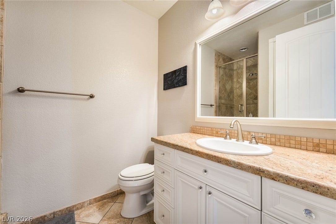 30 Via Vasari, #103, Henderson, NV 89011 Polished stone counters and matching tile floors accent this well-appointed bathroom.