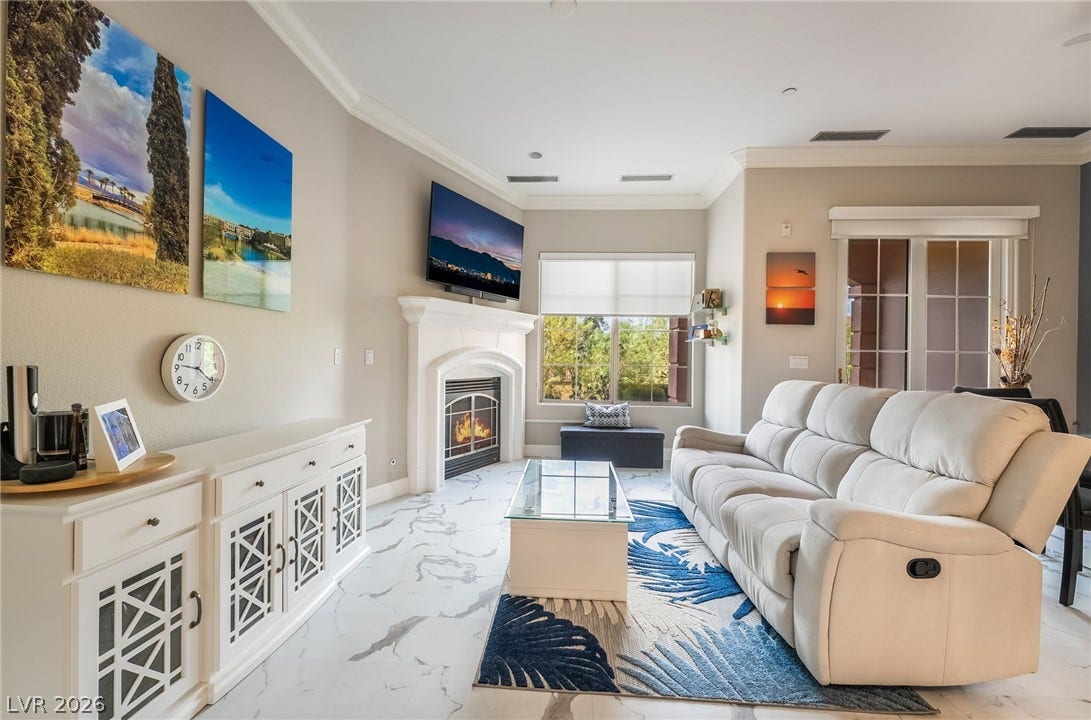 30 Via Vasari, #103, Henderson, NV 89011 Elegant crown molding and marble-look flooring define this welcoming living space with a classic fireplace.
