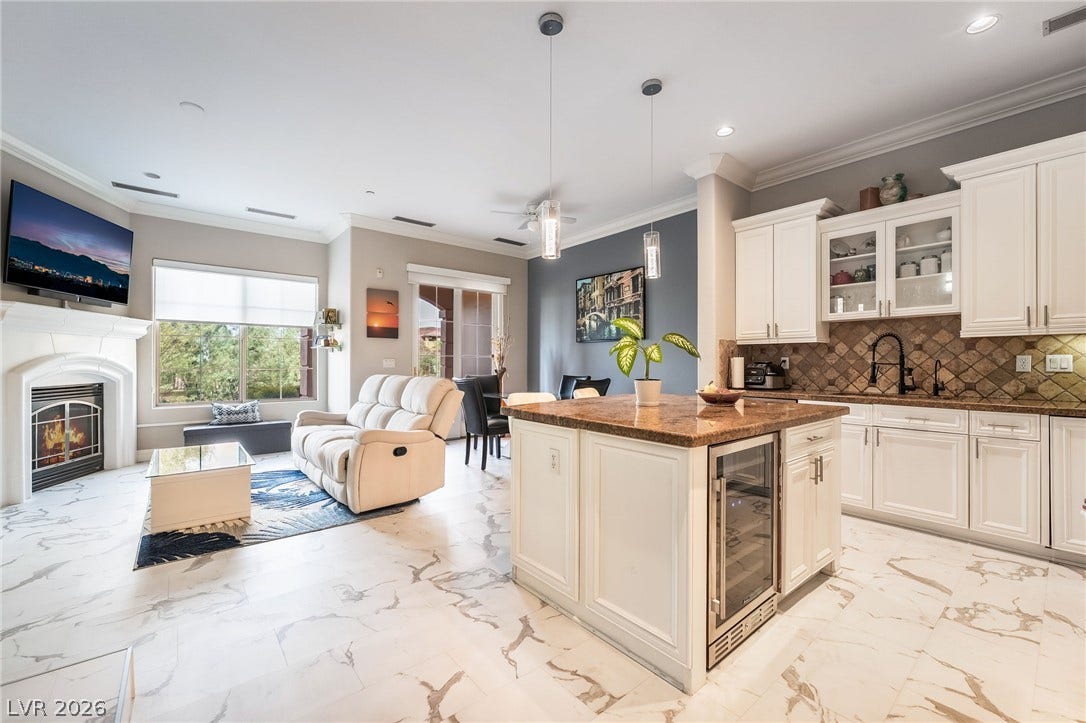30 Via Vasari, #103, Henderson, NV 89011 open living space anchored by a classic fireplace.