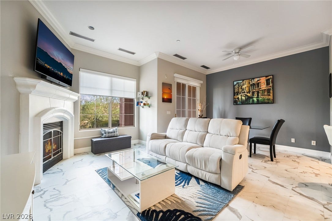 30 Via Vasari, #103, Henderson, NV 89011 Elegant crown molding and marble-patterned tile flooring elevate this open living and dining area.