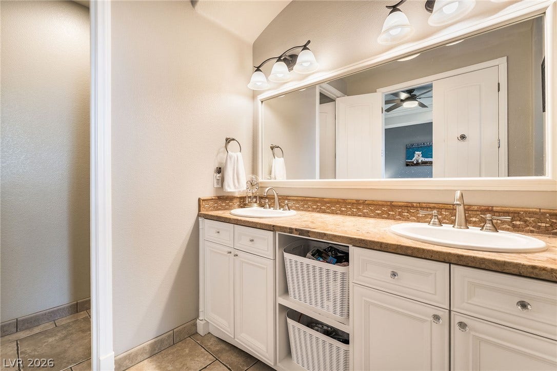 30 Via Vasari, #103, Henderson, NV 89011 A spacious double vanity with natural stone countertops highlights this elegant bathroom space.