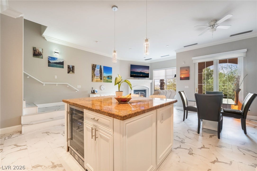30 Via Vasari, #103, Henderson, NV 89011 Gleaming stone tile floors flow throughout an airy, open-concept kitchen and dining area.