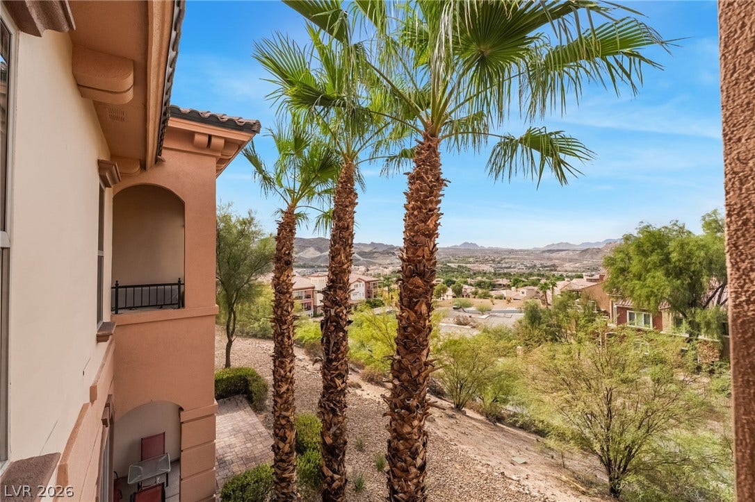 30 Via Vasari, #103, Henderson, NV 89011 Sweeping mountain and valley vistas frame this elegant exterior perspective accented by mature palm trees.