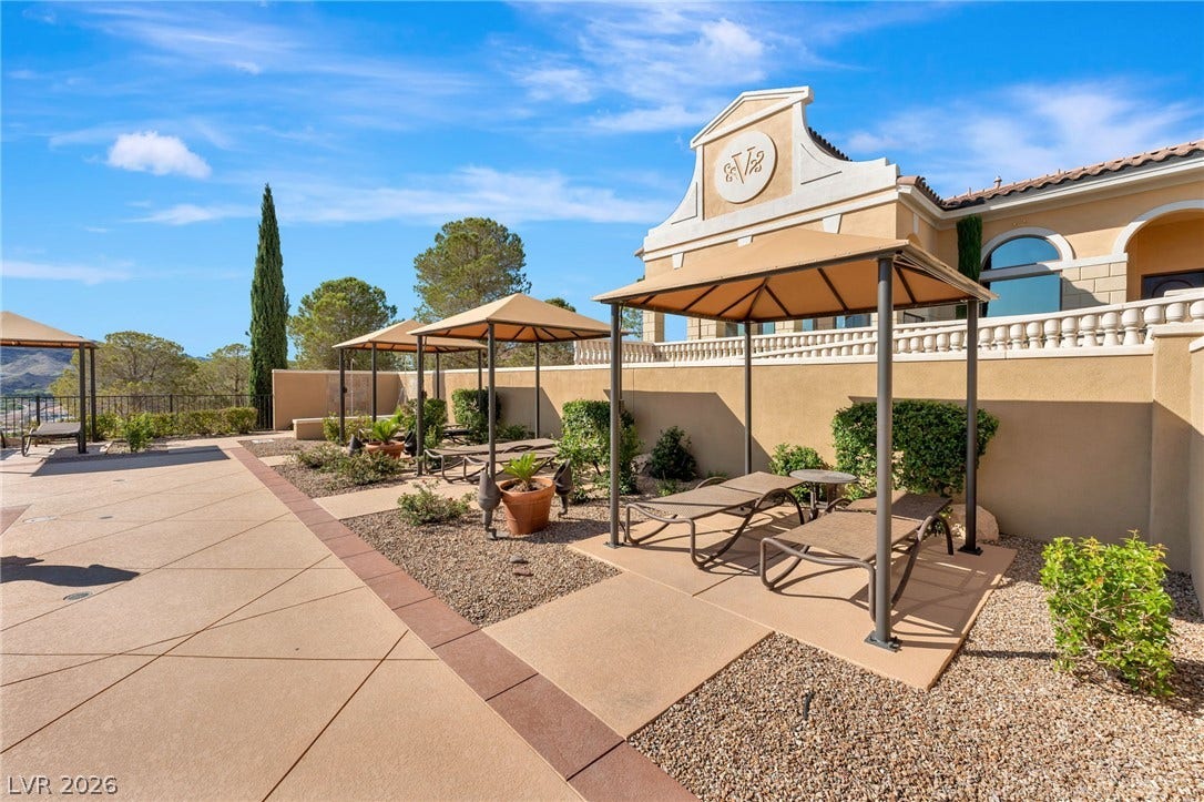 30 Via Vasari, #103, Henderson, NV 89011 Shaded poolside lounge areas offer a serene retreat under classic Mediterranean architecture.
