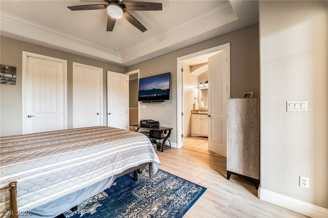 30 Via Vasari, #103, Henderson, NV 89011 Warm wood flooring and an elegant tray ceiling define this peaceful bedroom suite.