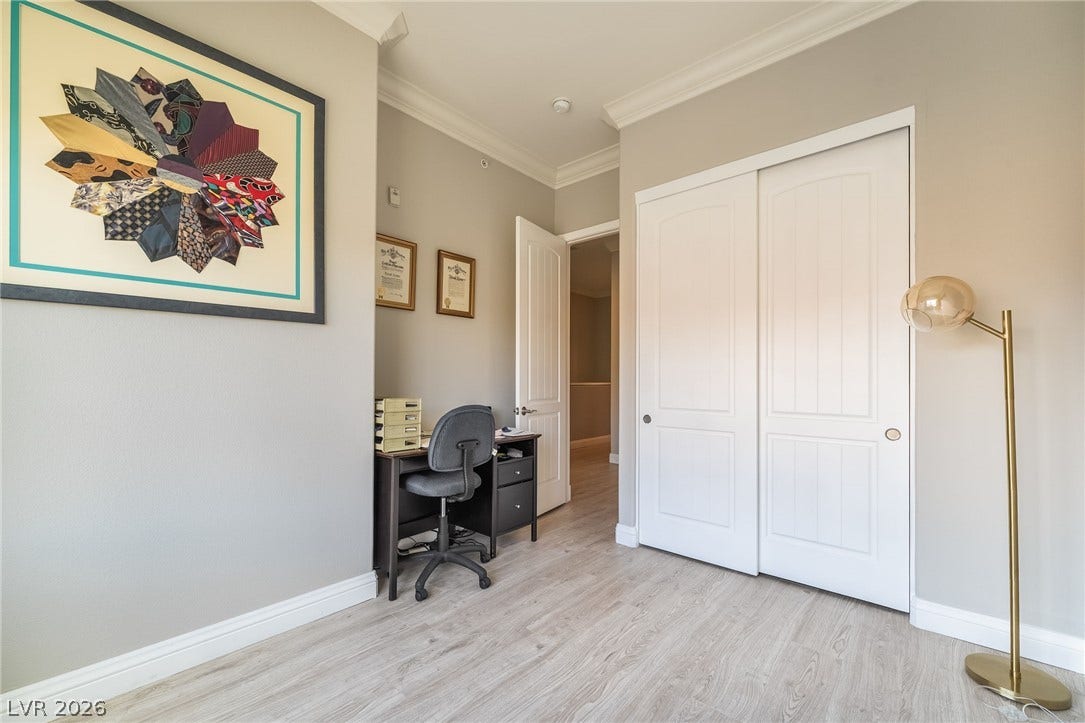 30 Via Vasari, #103, Henderson, NV 89011 Classic crown molding and durable wood flooring highlight this functional bedroom space.