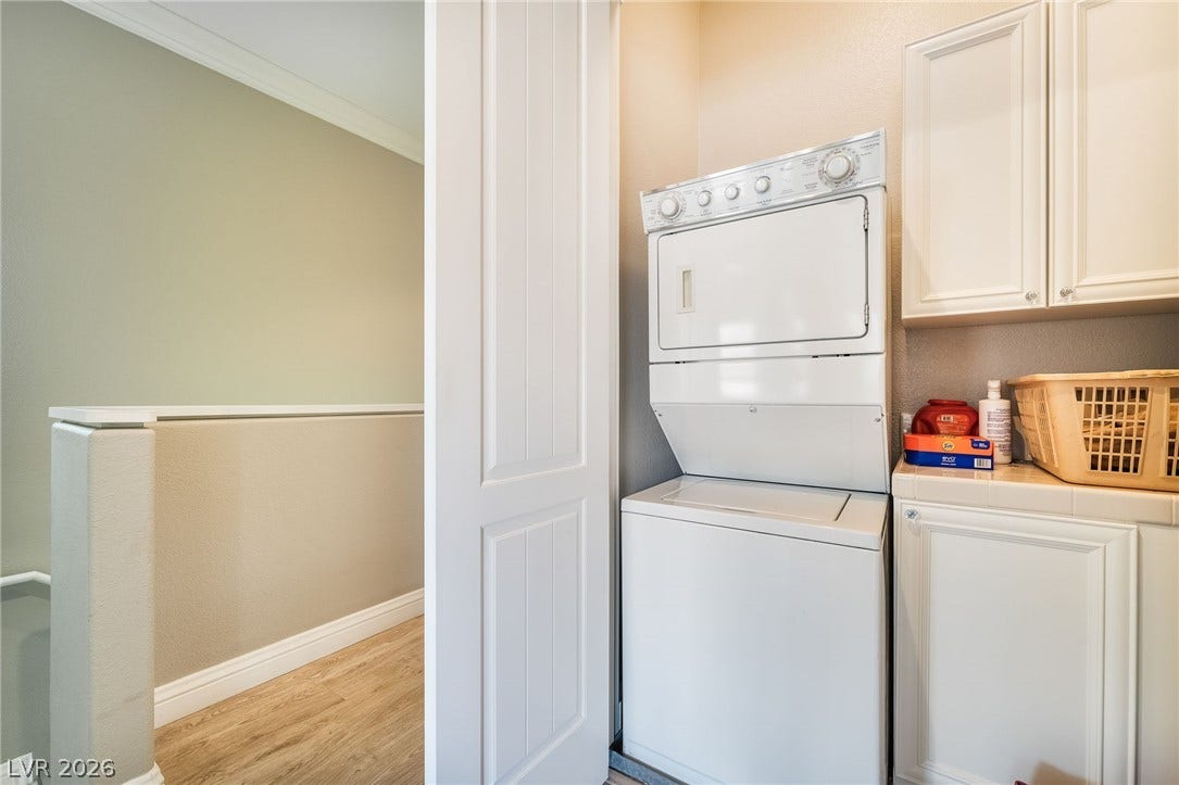 30 Via Vasari, #103, Henderson, NV 89011 An efficient laundry space features built-in cabinetry, tile countertops, and durable wood-look flooring.