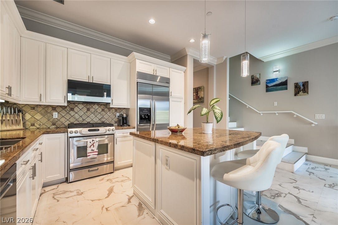 30 Via Vasari, #103, Henderson, NV 89011 Gleaming stone countertops and matching tiled flooring anchor this modern culinary space.