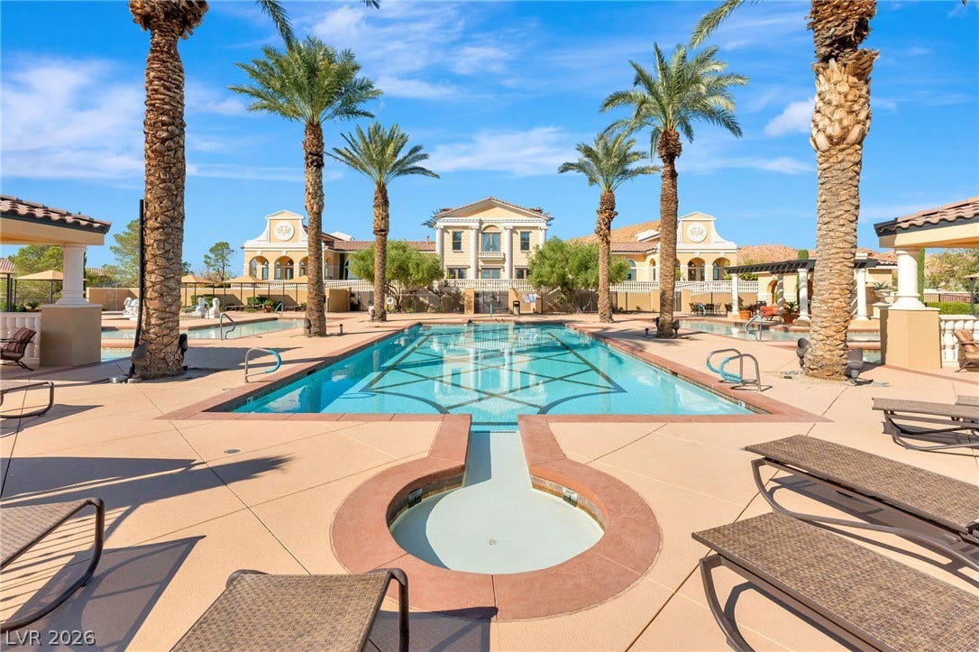 30 Via Vasari, #103, Henderson, NV 89011 Palm trees frame a sparkling swimming pool in front of a grand Mediterranean-style estate.