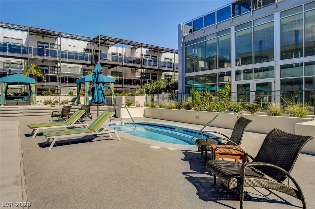 8925 W Flamingo Road, #111, Las Vegas, NV 89147 A sparkling in-ground spa sits on a spacious concrete patio surrounded by sleek modern architecture.