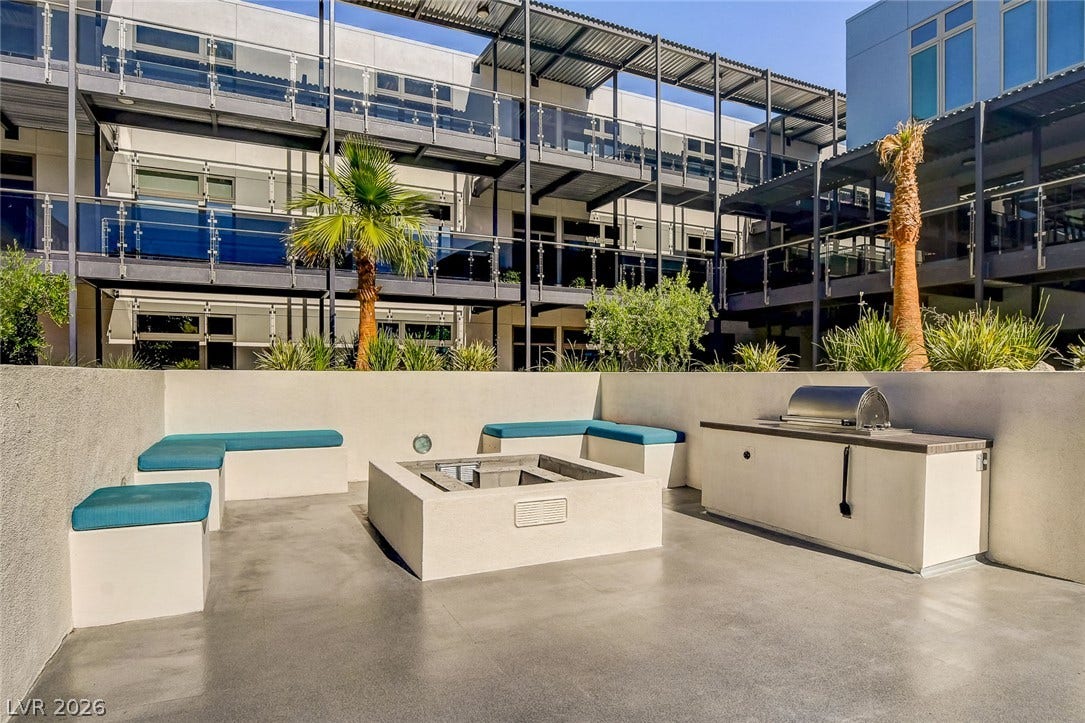 8925 W Flamingo Road, #111, Las Vegas, NV 89147 An inviting courtyard terrace features a built-in barbecue station alongside a modern gas fire pit.