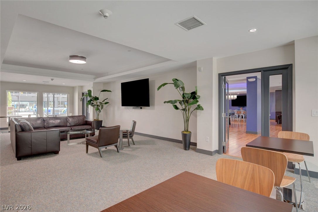 8925 W Flamingo Road, #111, Las Vegas, NV 89147 Recessed lighting and custom tray ceilings accent this spacious carpeted community lounge space.