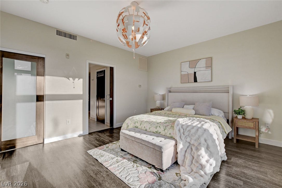8925 W Flamingo Road, #111, Las Vegas, NV 89147 Rich wood-look flooring and a modern light fixture elevate this tranquil bedroom.