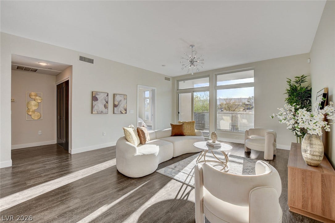 8925 W Flamingo Road, #111, Las Vegas, NV 89147 Rich wood-look flooring and sun-drenched glass doors define this open, airy living space.