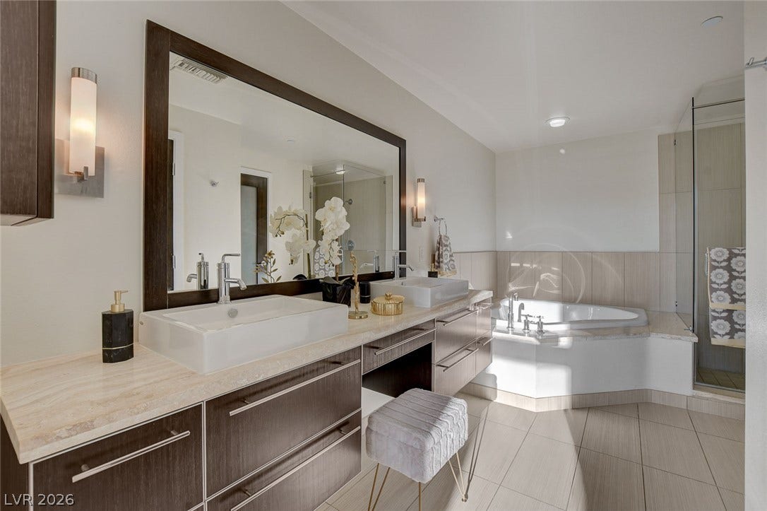 8925 W Flamingo Road, #111, Las Vegas, NV 89147 A spacious vanity with dual sinks anchors this modern bathroom featuring a deep soaking tub.