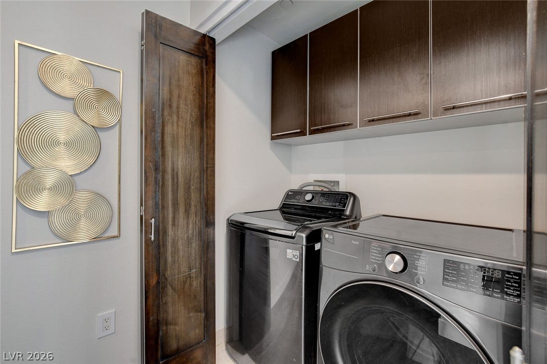 8925 W Flamingo Road, #111, Las Vegas, NV 89147 Rich wood cabinetry maximizes utility above the modern laundry appliances.