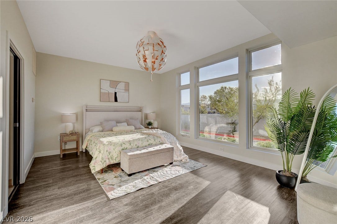 8925 W Flamingo Road, #111, Las Vegas, NV 89147 Towering windows flood this airy bedroom with abundant natural light across rich wood flooring.