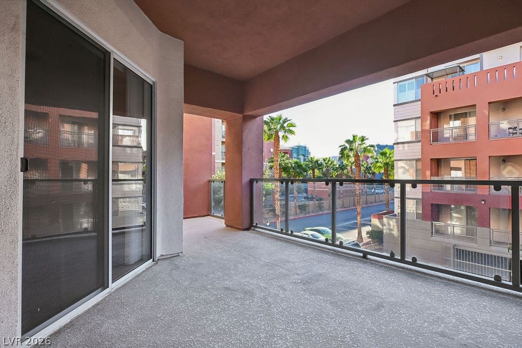 47 E Agate Avenue, #301, Las Vegas, NV 89123 Sliding glass doors open to a private covered balcony overlooking neighborhood streets and palm trees.