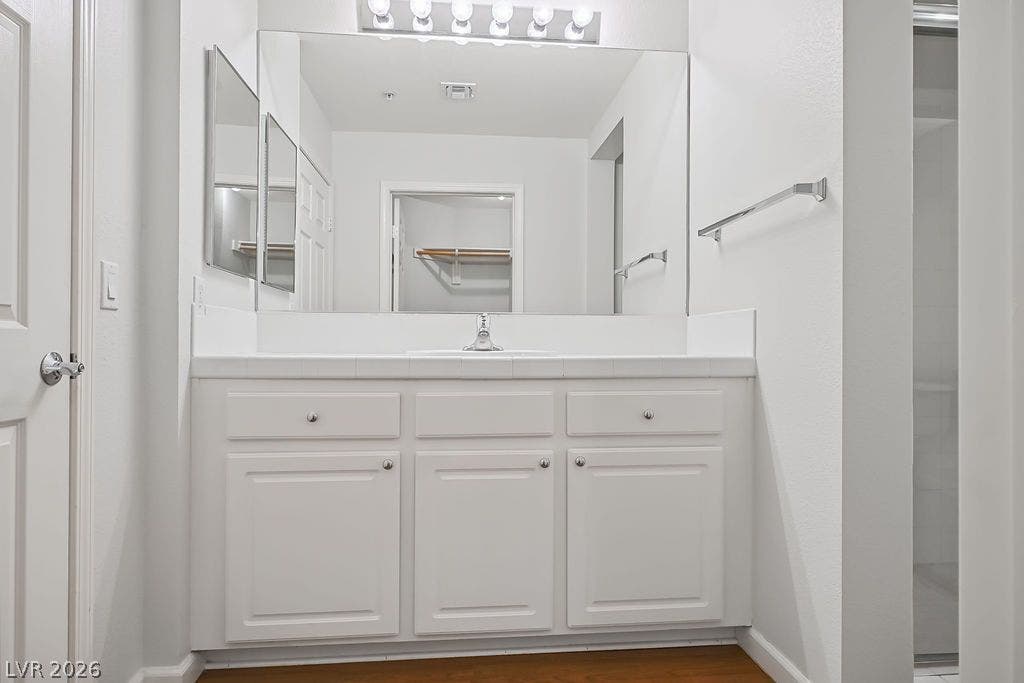 47 E Agate Avenue, #301, Las Vegas, NV 89123 A spacious vanity with ample storage sits beneath a wide mirror and classic lighting.