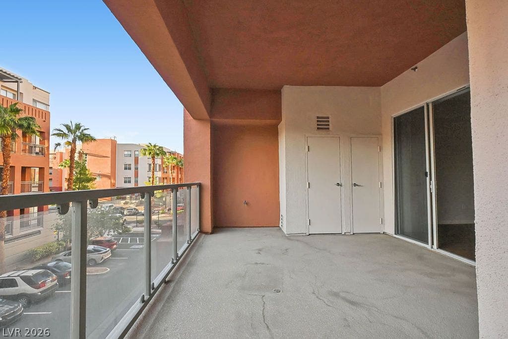 47 E Agate Avenue, #301, Las Vegas, NV 89123 Sliding glass doors open onto a covered concrete balcony overlooking the surrounding neighborhood.
