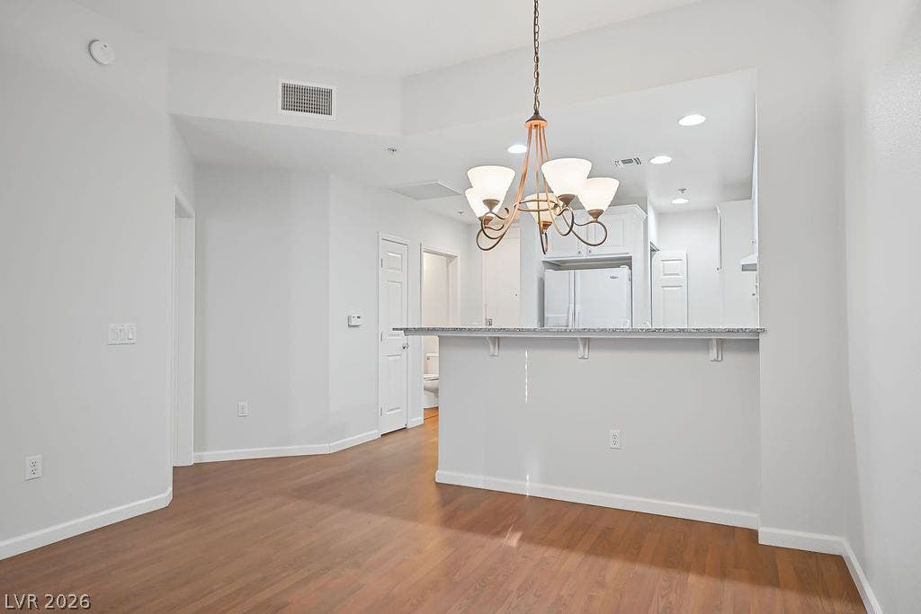 47 E Agate Avenue, #301, Las Vegas, NV 89123 An open pass-through kitchen counter connects seamlessly with the adjacent hardwood-floored dining area.
