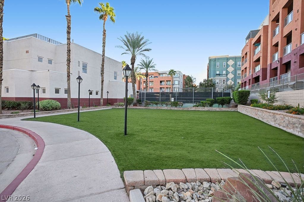47 E Agate Avenue, #301, Las Vegas, NV 89123 A curved concrete walkway leads past a manicured green lawn toward community amenities.