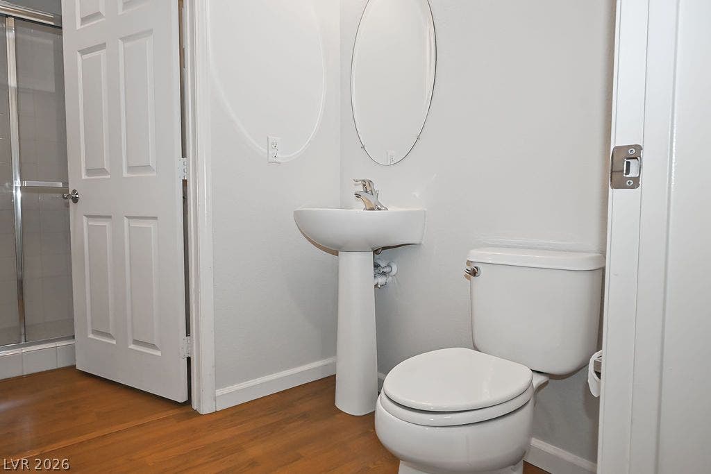 47 E Agate Avenue, #301, Las Vegas, NV 89123 A classic pedestal sink paired with warm wood floors creates a welcoming powder room.