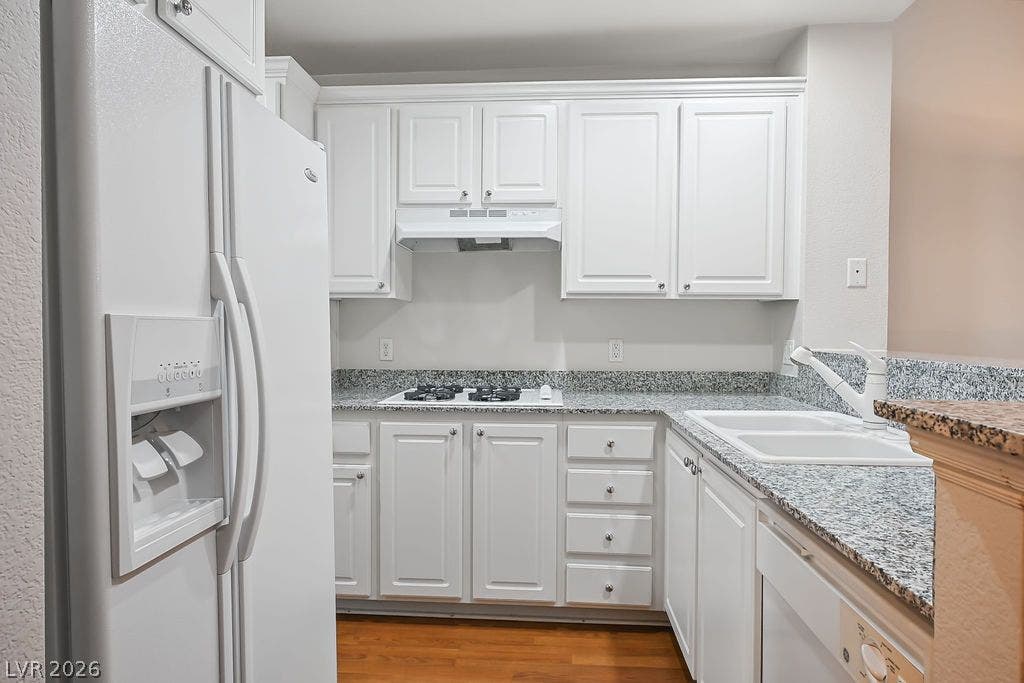 47 E Agate Avenue, #301, Las Vegas, NV 89123 Gleaming granite countertops pair with classic white cabinetry in this functional kitchen space.