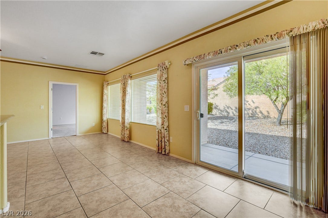 2612 Rock Pigeon Avenue, North Las Vegas, NV 89084 Sliding glass doors open directly to the backyard from this tile-floored living area.