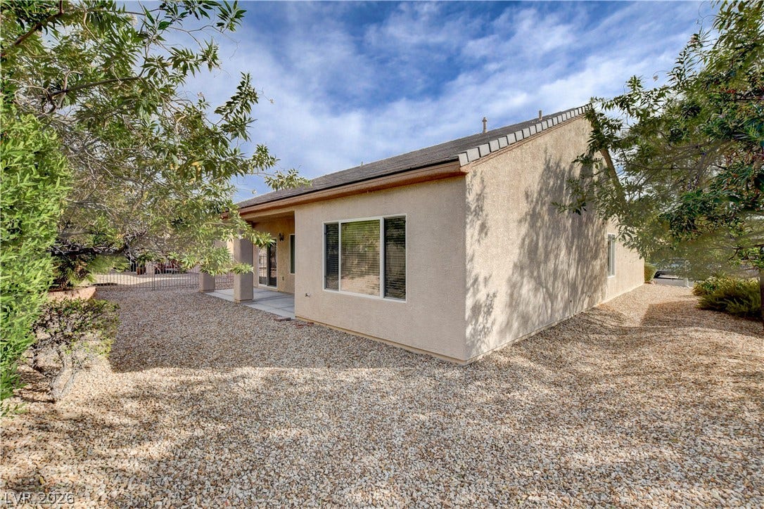2612 Rock Pigeon Avenue, North Las Vegas, NV 89084 Stucco exterior finishes and a low-maintenance gravel yard define the rear of this home.