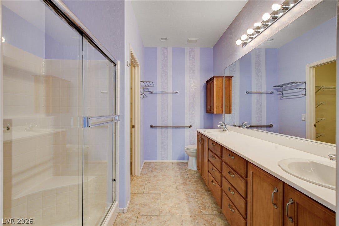2612 Rock Pigeon Avenue, North Las Vegas, NV 89084 A spacious bathroom layout features tiled flooring and an expansive double vanity with wooden cabinetry.