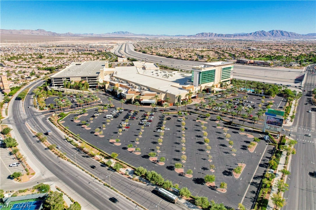 2612 Rock Pigeon Avenue, North Las Vegas, NV 89084 An aerial perspective showcases a commercial hub bordered by a sweeping mountain landscape.